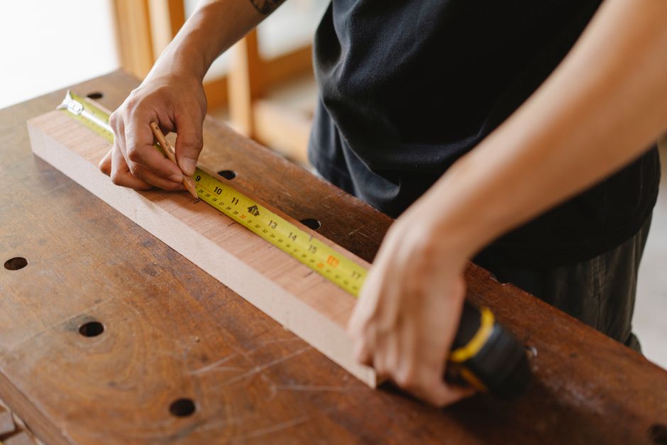 Carpenter measuring a window frame for a precise fit